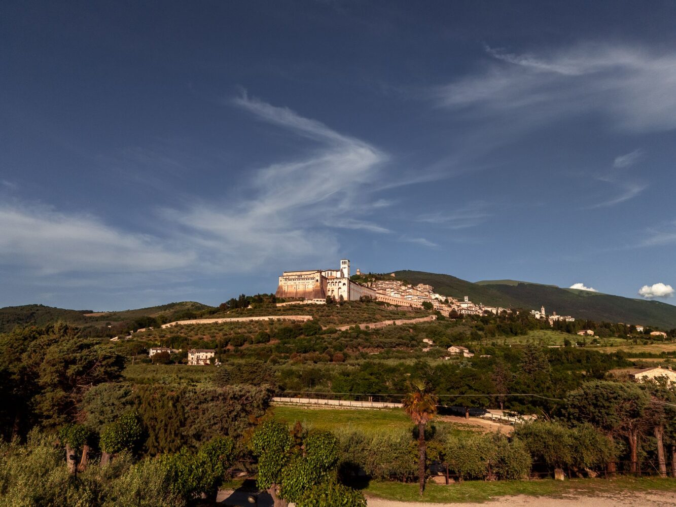 Il giardino estivo del Carfagna con tavoli apparecchiati e Assisi sullo sfondo